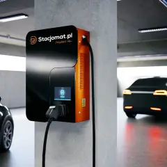 Stacja ładowania samochodu elektrycznego w garażu podziemnym. Nowoczesna ładowarka Stacjomat.pl gotowa do podłączenia pojazdu.