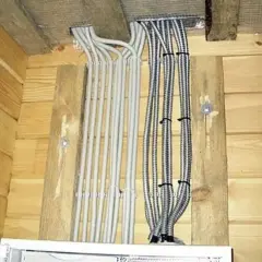 Przewody elektryczne w osłonach, starannie ułożone i przymocowane do drewnianych belek. Mocowanie przewodów elektrycznych do drewna wykonane estetycznie.
