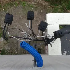 Widoczne połączenia kablowe, w tym niebieska peszla, wskazują na instalację elektryczną. To może być właśnie taki kabel od licznika do rozdzielni.