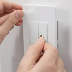 Ręce montują wyłącznik czasowy. Obok widoczny adapter WAGO.