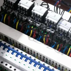 W tej instalacji elektrycznej widzimy przewody i wyłączniki, które pomagają nam zrozumieć, co mierzymy w amperach.