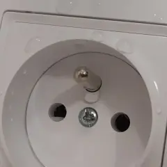 Bolec w gniazdku na górze czy na dole? Woda na białej ramce gniazdka elektrycznego.