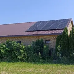 Panele fotowoltaiczne na dachu budynku gospodarczego. To rozwiązanie pozwala efektywnie zarządzać tym, jak wykorzystać nadmiar energii z fotowoltaiki, np. do magazynowania lub ogrzewania.