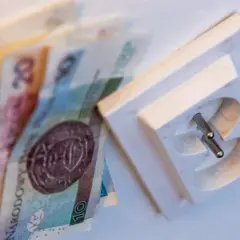 Pieniądze obok gniazdka elektrycznego. Dowiedz się, jak czytać rachunek za prąd PGE, by zrozumieć koszty.