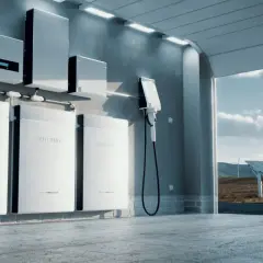 Nowoczesne baterie przyszłości w garażu, gotowe do ładowania. W tle panele słoneczne i wiatraki.