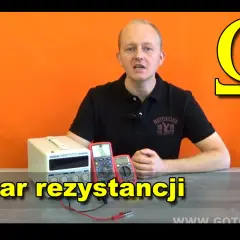 Mężczyzna prezentuje mierniki i zasilacz, omawiając pomiar rezystancji. Symbol Omegi, jednostka rezystywności, widoczny w tle.