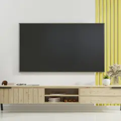 Nowoczesny salon z telewizorem na ścianie, pod którym znajduje się drewniana szafka. Prowadzenie kabli po ścianie jest dyskretne.