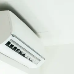Biała jednostka klimatyzacyjna zamontowana na ścianie, zapewniająca komfortowe ogrzewanie i chłodzenie.
