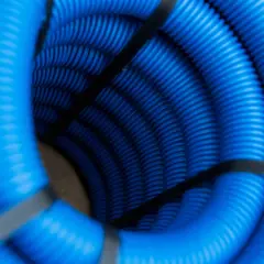Zwijający się w spiralę, niebieski peszel, z czarną taśmą spinającą. Widać jego karbowaną strukturę.