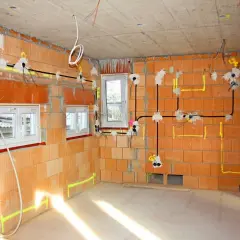 Budowa domu w toku: instalacja elektryczna z przewodami, puszki i okablowanie. Widać, ile kw na kablu 3x2,5 jest potrzebne do zasilenia gniazdek i oświetlenia.