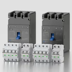 Dwa duże szare i cztery mniejsze białe wyłączniki elektryczne na jasnym tle.