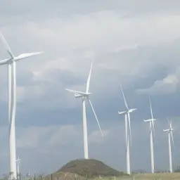 Wiatraki na tle chmur. Zastanawiasz się, ile wiatrak produkuje energii na godzinę?