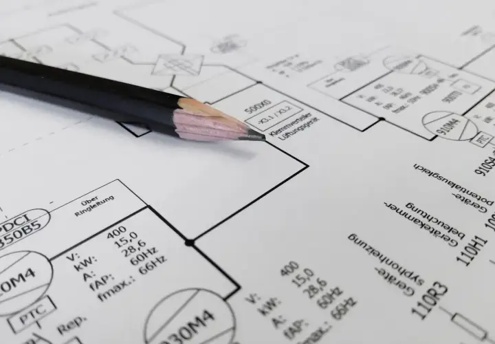 Ołówek na schemacie instalacji elektrycznej. Czy panele fotowoltaiczne trzeba zgłaszać? Dokumentacja techniczna zawiera dane urządzeń.