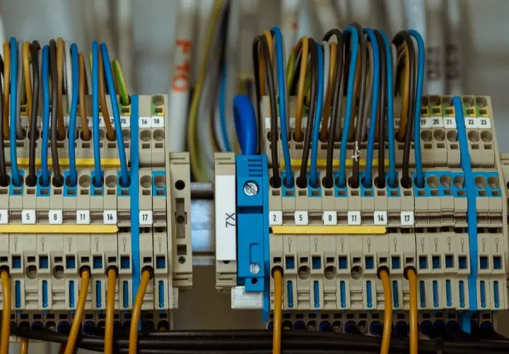 Zaciski elektryczne z kolorowymi przewodami tworzą skomplikowane przyłącze prądu.