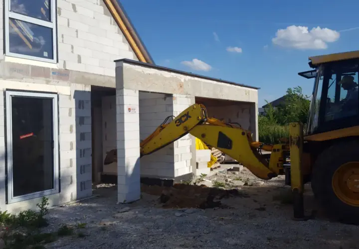 Budowa domu w toku. Koparka pracuje przy fundamentach. Czy wlz czy potrzebny projekt?