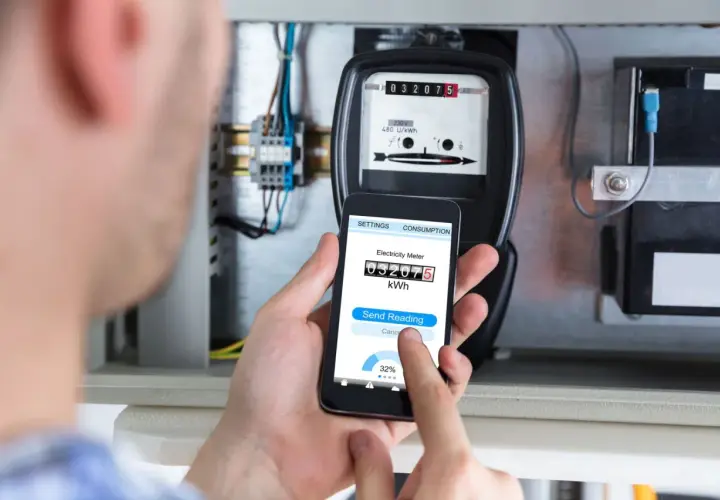 Zdalny odczyt licznika energii elektrycznej za pomocą smartfona. Na ekranie telefonu widoczny jest aktualny stan licznika.