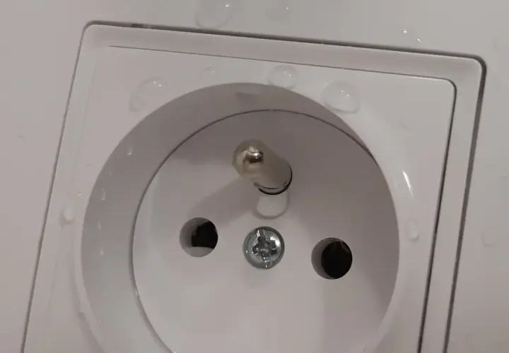 Bolec w gniazdku na górze czy na dole? Woda na białej ramce gniazdka elektrycznego.