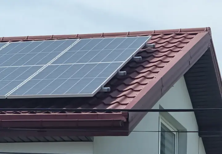 Panele fotowoltaiczne na dachu domu, zbierające energię słoneczną.