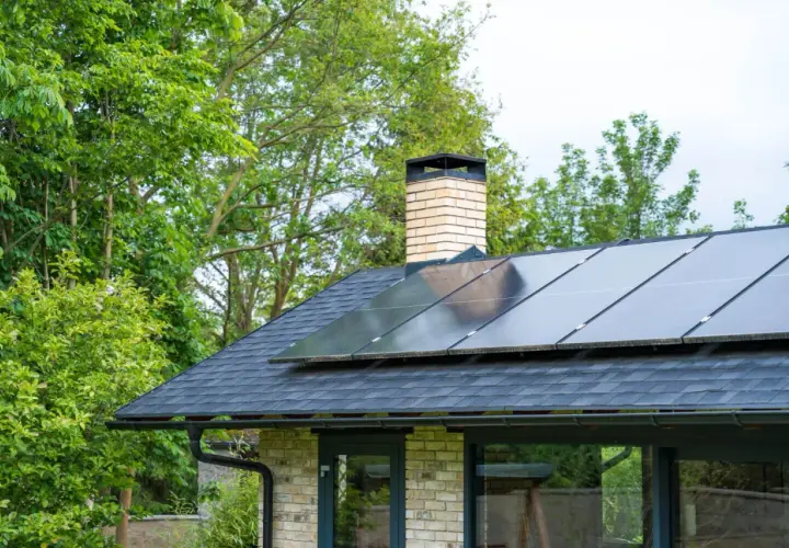 Nowoczesny dom z panelami fotowoltaicznymi na dachu, zapewniającymi ekologiczne ogrzewanie.