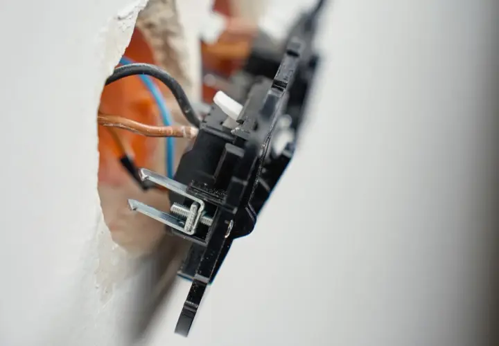 Widok z bliska na instalację elektryczną: widoczne przewody i mechanizm wypustu zasilającego 1 fazowy w trakcie montażu.