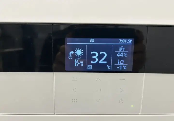 Wyświetlacz pokazuje temperaturę wody w podłogówce 32°C. Obok widać temperaturę wody użytkowej 44°C i temperaturę zewnętrzną -1°C.