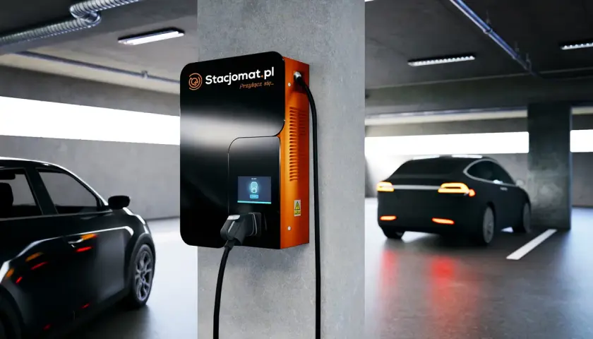 Stacja ładowania samochodu elektrycznego w garażu podziemnym. Nowoczesna ładowarka Stacjomat.pl gotowa do podłączenia pojazdu.