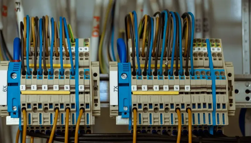 Zaciski elektryczne z kolorowymi przewodami tworzą skomplikowane przyłącze prądu.