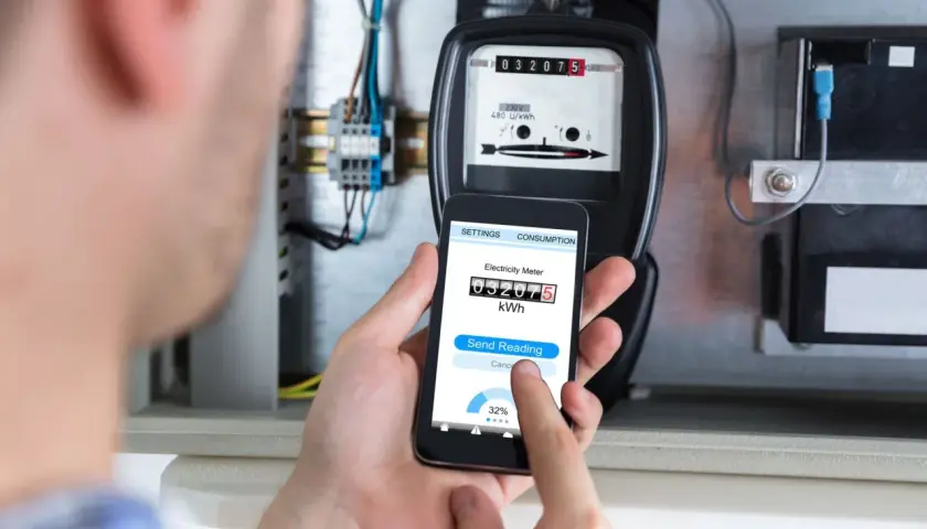 Zdalny odczyt licznika energii elektrycznej za pomocą smartfona. Na ekranie telefonu widoczny jest aktualny stan licznika.
