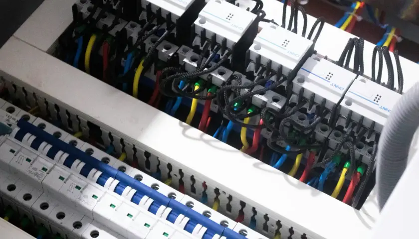 W tej instalacji elektrycznej widzimy przewody i wyłączniki, które pomagają nam zrozumieć, co mierzymy w amperach.