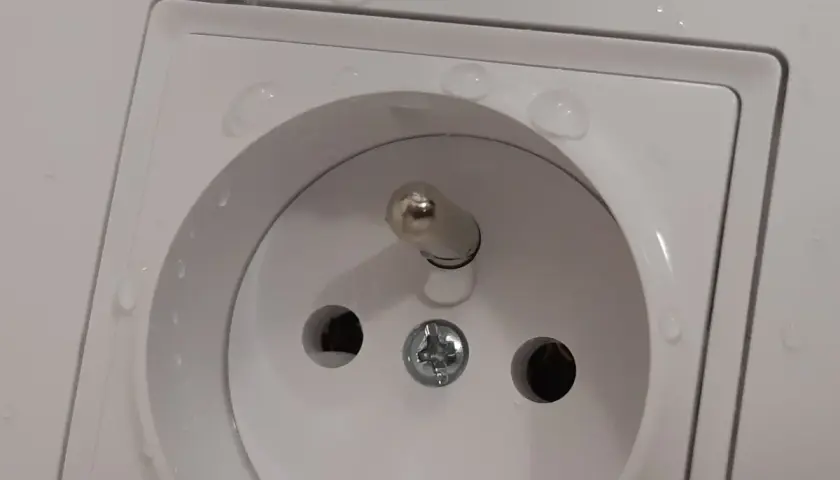 Bolec w gniazdku na górze czy na dole? Woda na białej ramce gniazdka elektrycznego.
