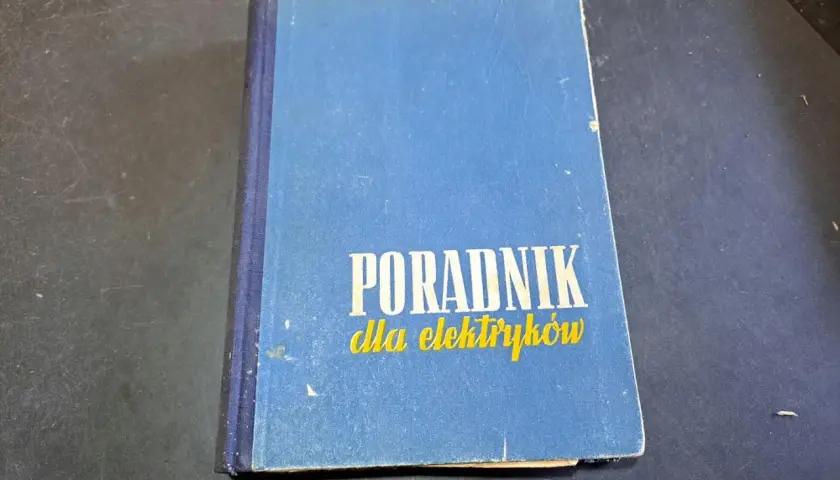 Niebieski poradnik dla elektryków, zawierający cenną wiedzę z zakresu elektryki.