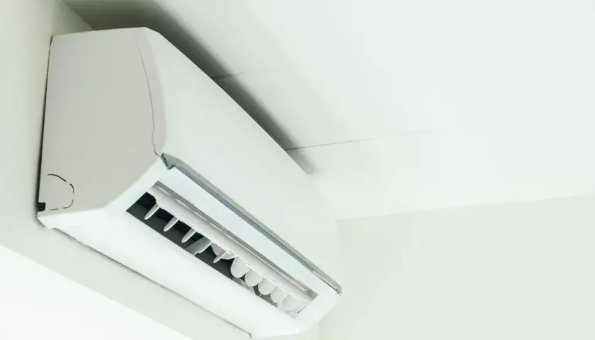 Biała jednostka klimatyzacyjna zamontowana na ścianie, zapewniająca komfortowe ogrzewanie i chłodzenie.