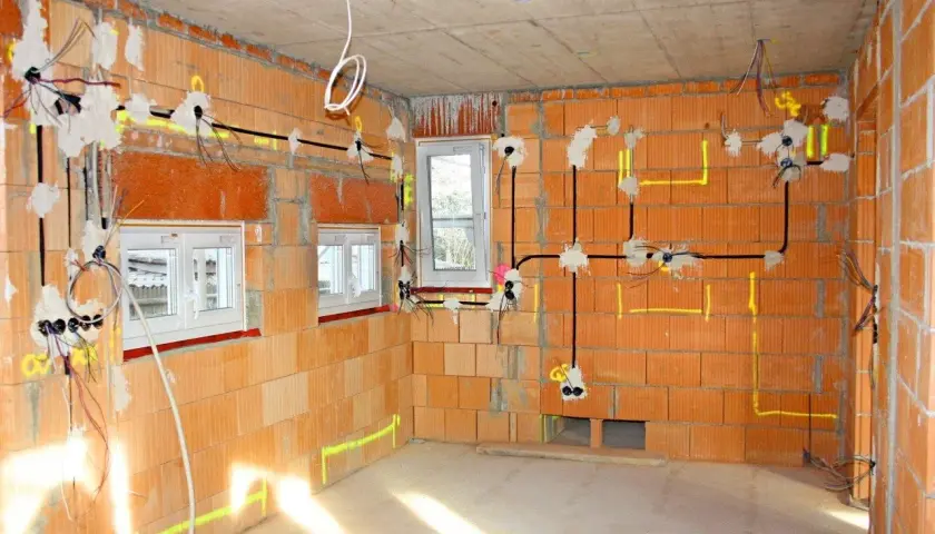 Budowa domu w toku: instalacja elektryczna z przewodami, puszki i okablowanie. Widać, ile kw na kablu 3x2,5 jest potrzebne do zasilenia gniazdek i oświetlenia.