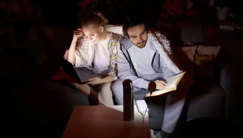 Para dowiedzieć się, dlaczego w połowie domu nie ma prądu, siedzi pod kocem. Ona pracuje na laptopie, on czyta książkę, oświetloną małą lampką z powerbanku.