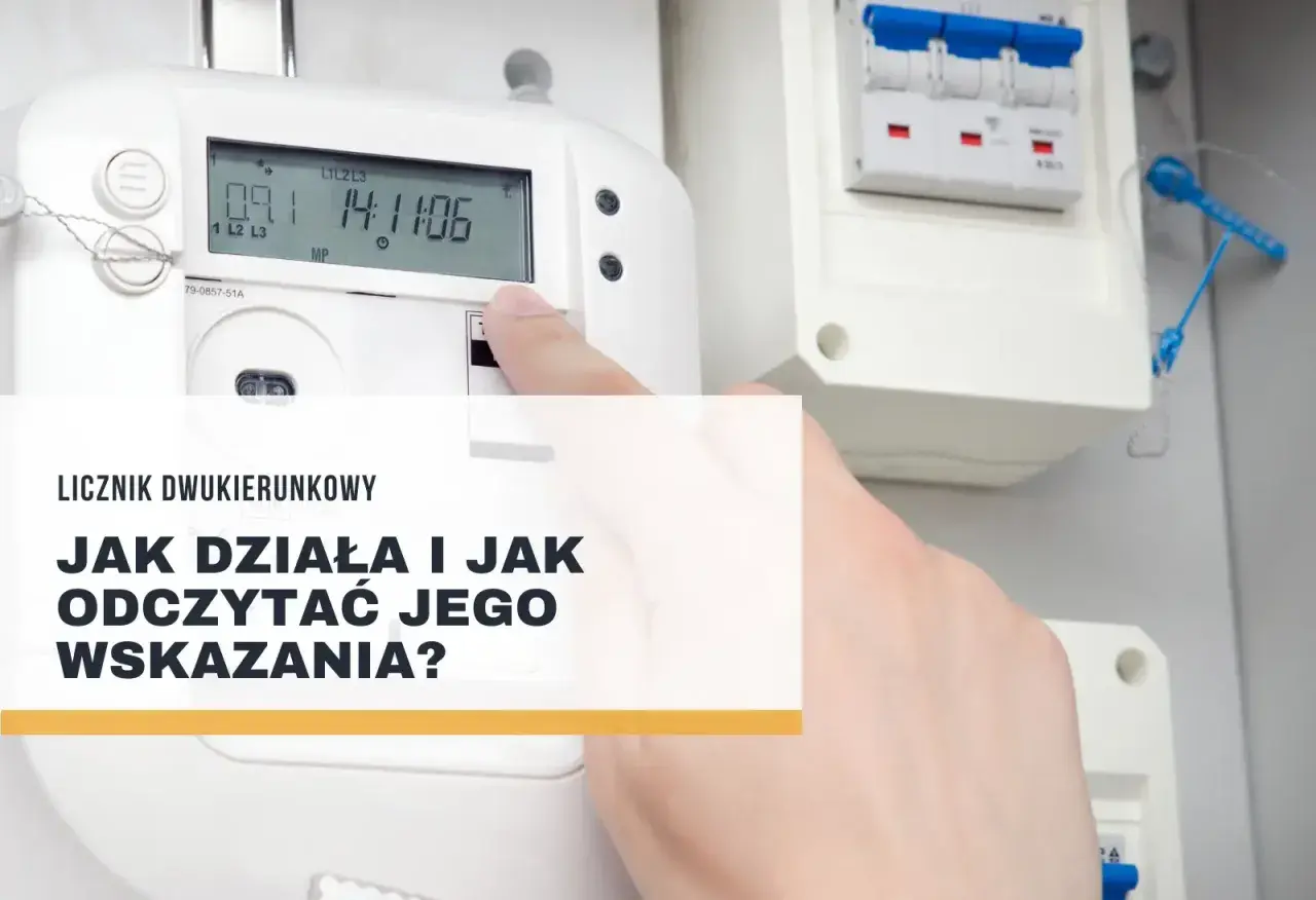 Palec wskazuje na ekran licznika dwukierunkowego, pokazując jego odczyty. Obok widoczne są bezpieczniki.