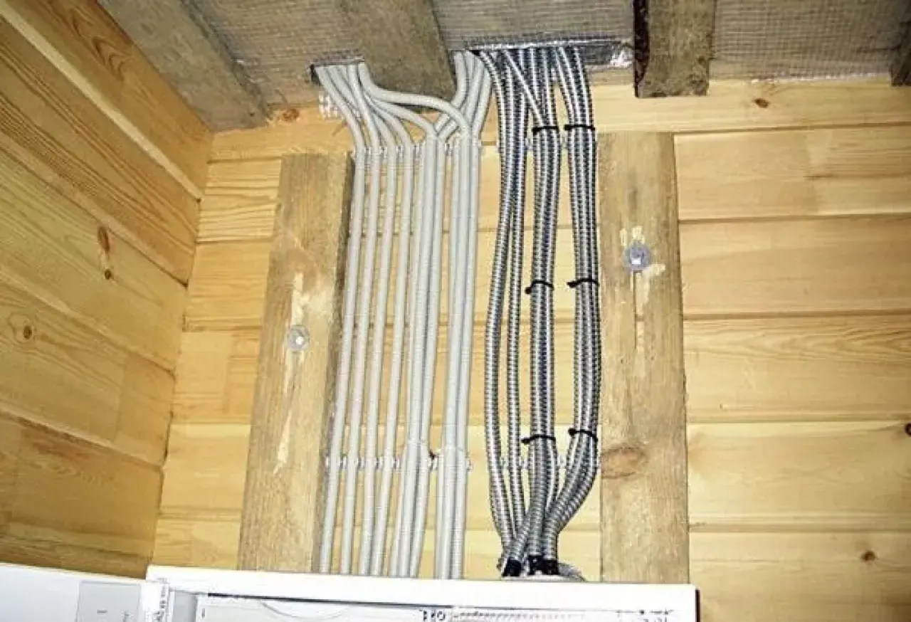 Przewody elektryczne w osłonach, starannie ułożone i przymocowane do drewnianych belek. Mocowanie przewodów elektrycznych do drewna wykonane estetycznie.