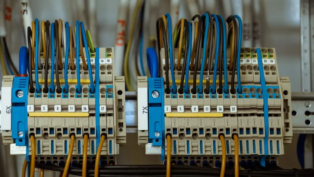 Zaciski elektryczne z kolorowymi przewodami tworzą skomplikowane przyłącze prądu.