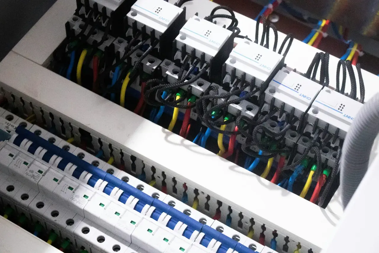 W tej instalacji elektrycznej widzimy przewody i wyłączniki, które pomagają nam zrozumieć, co mierzymy w amperach.