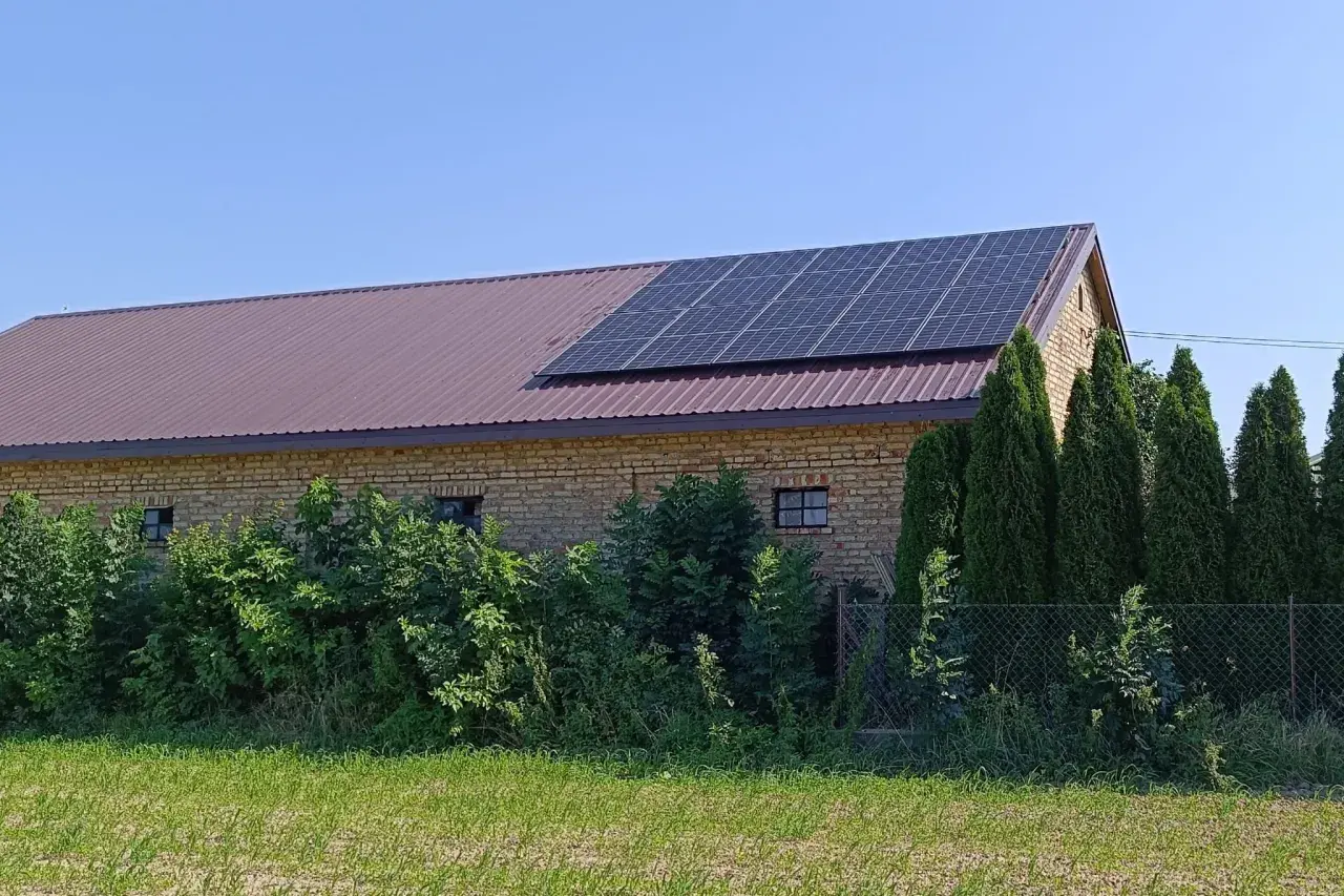 Panele fotowoltaiczne na dachu budynku gospodarczego. To rozwiązanie pozwala efektywnie zarządzać tym, jak wykorzystać nadmiar energii z fotowoltaiki, np. do magazynowania lub ogrzewania.