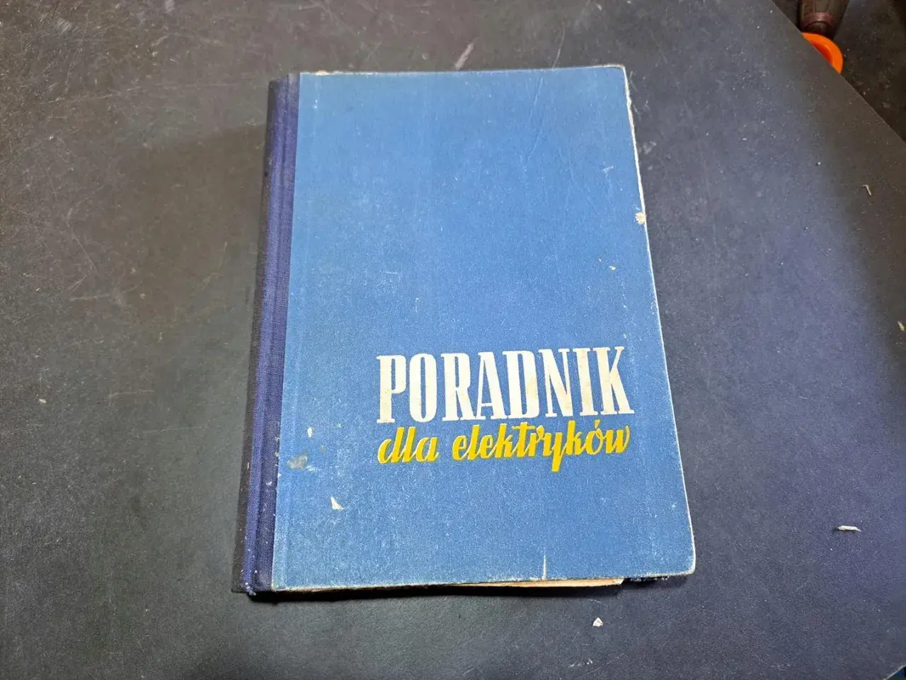 Niebieski poradnik dla elektryków, zawierający cenną wiedzę z zakresu elektryki.