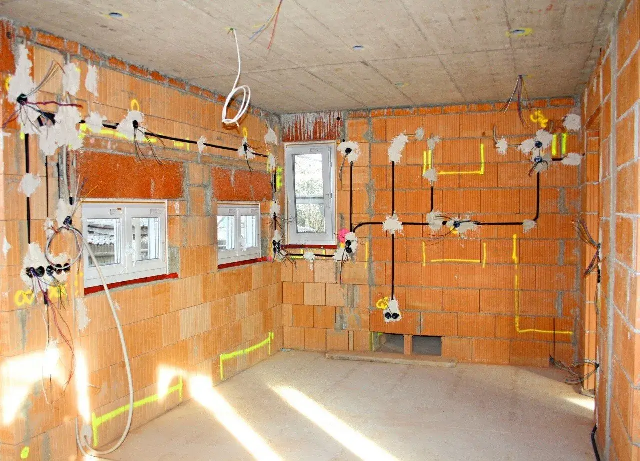 Budowa domu w toku: instalacja elektryczna z przewodami, puszki i okablowanie. Widać, ile kw na kablu 3x2,5 jest potrzebne do zasilenia gniazdek i oświetlenia.