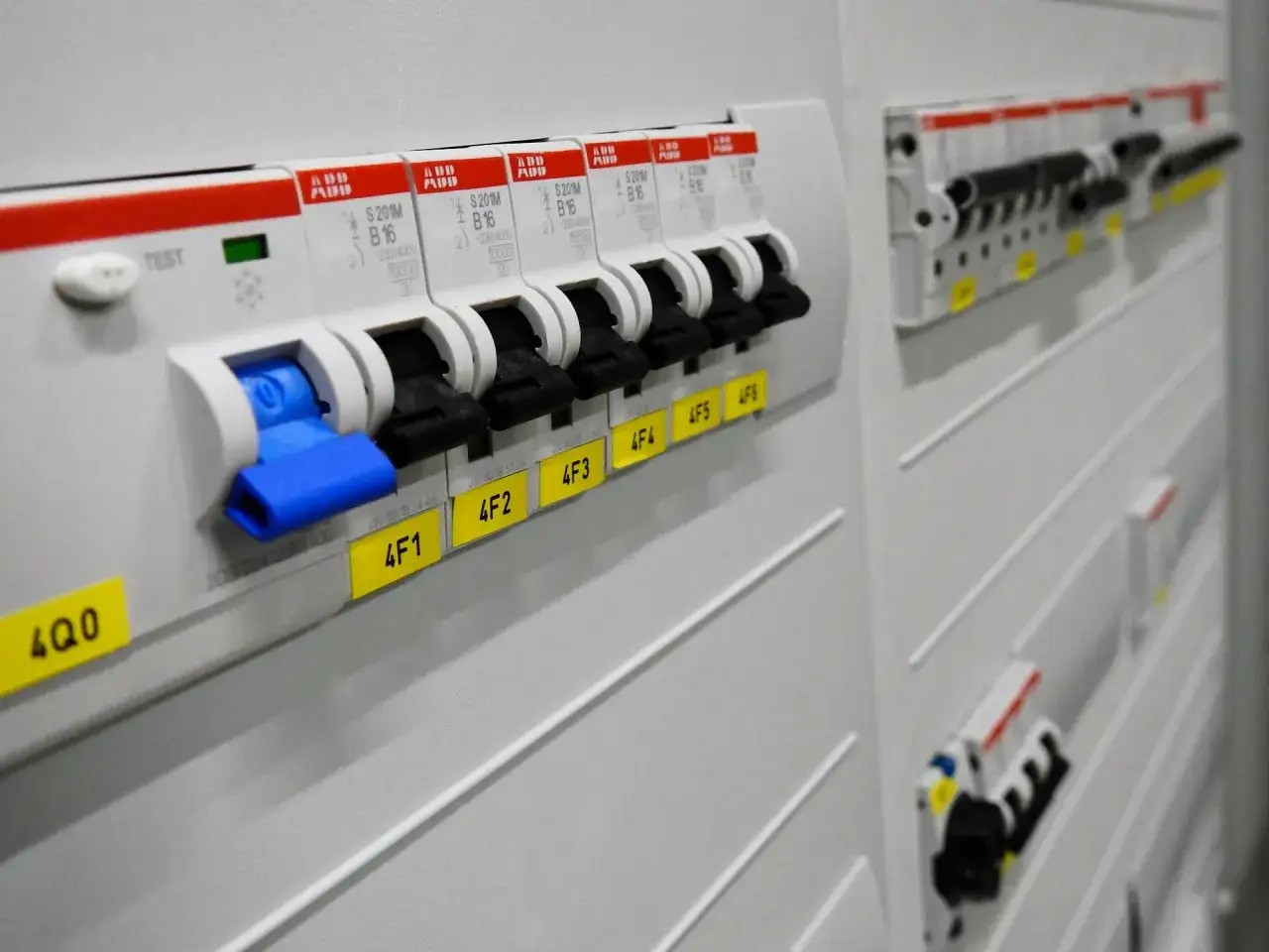 Panel z wyłącznikami. Widać kilka obwodów na jednej różnicówce, oznaczonych etykietami 4F1, 4F2, 4F3, 4F4, 4F5, 4F6.