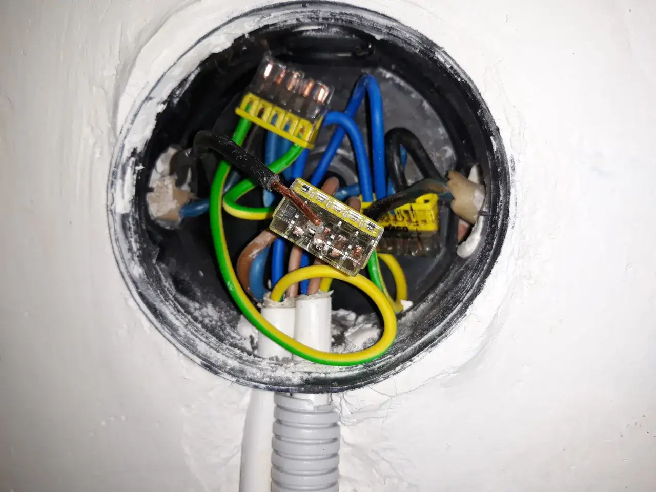 Widać przewody elektryczne w puszce, przygotowane do podłączenia gniazdka w starej instalacji. Użyto złączek WAGO.