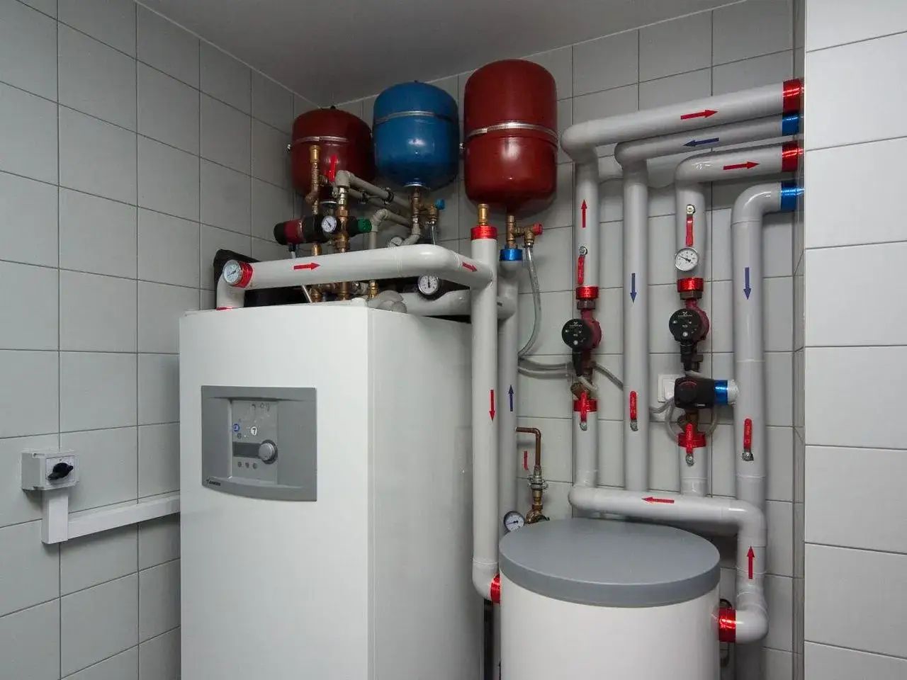 Pompa ciepła z instalacją hydrauliczną, zbiornikami i manometrami.