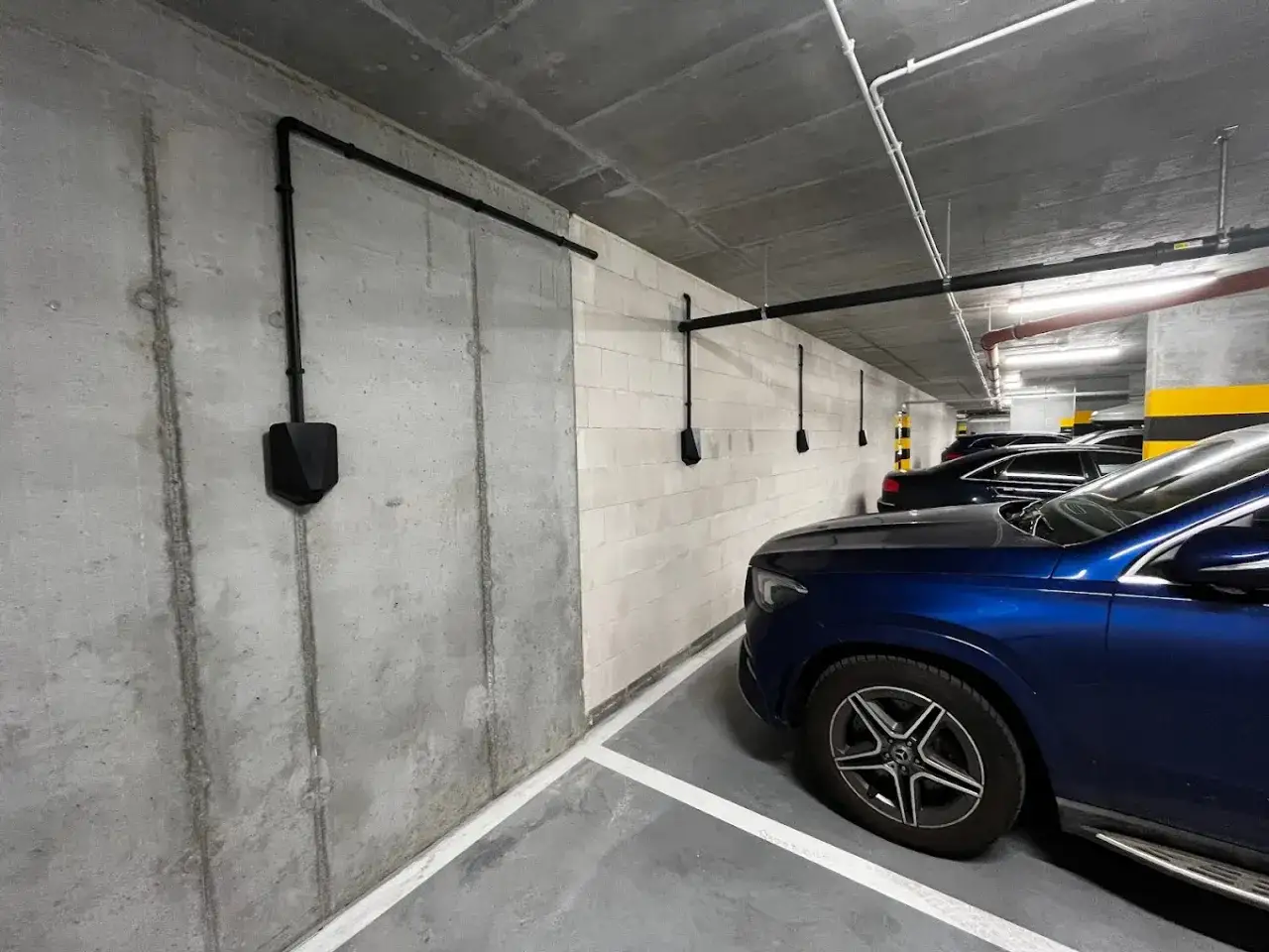 Nowoczesne ładowanie samochodu elektrycznego w garażu podziemnym. Kilka stacji ładowania zainstalowanych zgodnie z przepisami, gotowych do użytku.
