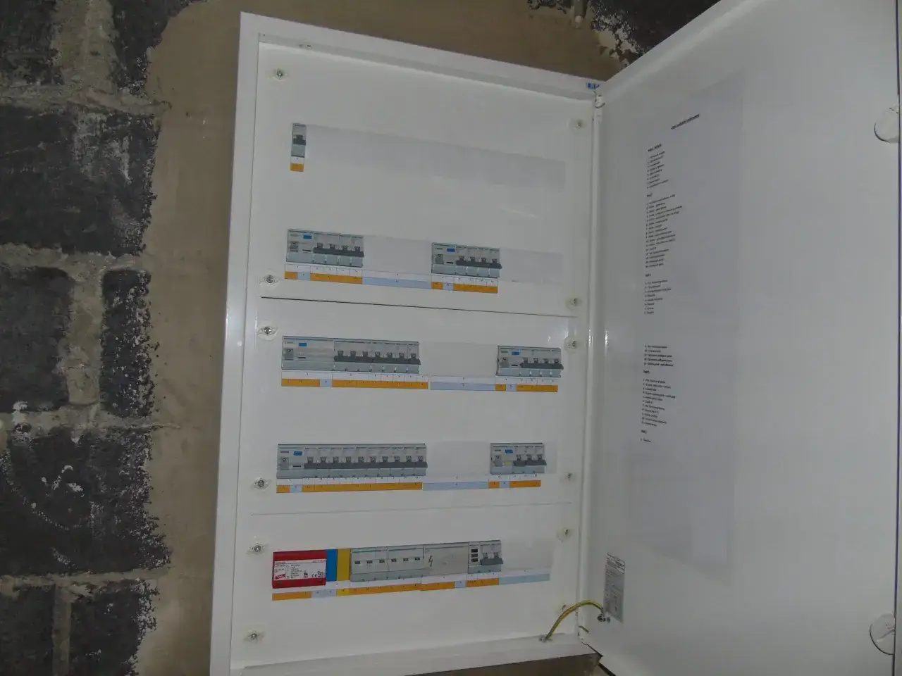 W skrzynce elektrycznej widać kilka zabezpieczeń, w tym wyłączniki nadprądowe i jedną różnicówkę. To pozwala ocenić, ile różnicówek w domu jest potrzebnych.